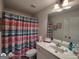 Bright bathroom featuring a vanity with sink, toilet, and colorful striped shower curtain at 1292 Hidden Spirit Trl, Lawrenceville, GA 30045
