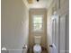 Neutral bathroom featuring a toilet, window, and a white door at 1292 Hidden Spirit Trl, Lawrenceville, GA 30045