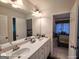 Bathroom featuring dual sinks, modern fixtures, and view of the bedroom in the mirror at 1292 Hidden Spirit Trl, Lawrenceville, GA 30045