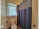 Bathroom with blue shower curtain, toilet, and window for natural light at 1292 Hidden Spirit Trl, Lawrenceville, GA 30045
