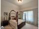 Bedroom featuring a canopy bed, bedside tables, and soft lighting from sheer curtains at 1292 Hidden Spirit Trl, Lawrenceville, GA 30045