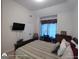 This bedroom has a TV on the wall, a desk by the window, and crown molding at 1292 Hidden Spirit Trl, Lawrenceville, GA 30045