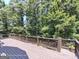 Spacious wooden deck with railing, offering a serene view of the surrounding trees and greenery at 1292 Hidden Spirit Trl, Lawrenceville, GA 30045