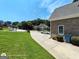 Side view of a home featuring a long driveway, well-maintained lawn, and established landscaping at 1292 Hidden Spirit Trl, Lawrenceville, GA 30045