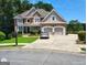 Beautiful two-story brick home with a well-manicured lawn, two car garage, and mature trees at 1292 Hidden Spirit Trl, Lawrenceville, GA 30045