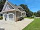 Side view of a brick house highlighting the two-car garage, driveway, and well-maintained landscaping at 1292 Hidden Spirit Trl, Lawrenceville, GA 30045
