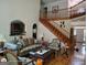 Bright living room with a wooden staircase, hardwood floors, and traditional-style furniture at 1292 Hidden Spirit Trl, Lawrenceville, GA 30045