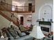 Comfortable living room showcasing a fireplace, hardwood floors, staircase, and access to other living spaces at 1292 Hidden Spirit Trl, Lawrenceville, GA 30045