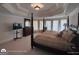 Large bedroom with a four poster bed, many windows, and a television set at 1292 Hidden Spirit Trl, Lawrenceville, GA 30045