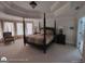 Spacious main bedroom with a four-poster bed, soft lighting, and neutral carpet at 1292 Hidden Spirit Trl, Lawrenceville, GA 30045