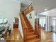 Elegant foyer with wood staircase and decorative pillars leading to living area with hardwood floors at 1292 Hidden Spirit Trl, Lawrenceville, GA 30045
