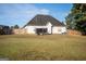 Spacious backyard features a lush lawn, a black trailer, and a sturdy wood fence for privacy at 609 Alyssa Ct, Locust Grove, GA 30248