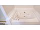 Close up on jetted tub with tile surround and gold fixtures at 609 Alyssa Ct, Locust Grove, GA 30248