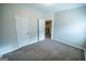 Empty bedroom shows the ensuite washer and dryer, neutral walls, carpet, and closet at 609 Alyssa Ct, Locust Grove, GA 30248