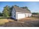 Garage of the house features a white garage door, black landscaping rock, and green yard at 609 Alyssa Ct, Locust Grove, GA 30248