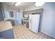 Well-lit kitchen with gray cabinetry and white appliances, and neutral tile flooring at 609 Alyssa Ct, Locust Grove, GA 30248