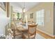 Well-lit dining room featuring a wood table, six upholstered chairs, and charming decor at 512 Las Brasis Ct, Peachtree City, GA 30269
