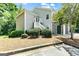 Two-story home with light gray siding, stone accents, stairs, and lush landscaping at 512 Las Brasis Ct, Peachtree City, GA 30269