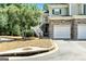 Two-story home with stone accents, white garage doors, and manicured lawn with green trees at 512 Las Brasis Ct, Peachtree City, GA 30269
