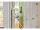 Hallway leading to a bright, airy room with hardwood floors, connecting different spaces in the home at 512 Las Brasis Ct, Peachtree City, GA 30269