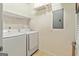 Functional laundry room with washer, dryer, and storage shelving at 512 Las Brasis Ct, Peachtree City, GA 30269