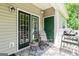 Relaxing outdoor patio with rocking chair, small table, and green accents at 512 Las Brasis Ct, Peachtree City, GA 30269