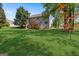 Expansive backyard featuring lush green lawn, mature trees, and a wooden deck accessible from the second story at 419 Tea Rose N Ln, Stockbridge, GA 30281