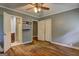 Bedroom with hardwood floors, ceiling fan, two windows, closet, and gray walls at 2742 Highway 20 W, Hampton, GA 30228