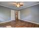 Bedroom with hardwood floors, gray walls, ceiling fan, and doorways leading to other rooms at 2742 Highway 20 W, Hampton, GA 30228