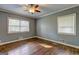 Neutral bedroom featuring hardwood floors, a ceiling fan, two windows, and natural light at 2742 Highway 20 W, Hampton, GA 30228