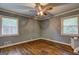 Bedroom with hardwood floors, ceiling fan, two windows, and neutral walls with white trim at 2742 Highway 20 W, Hampton, GA 30228