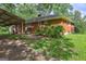 Exterior side view of the home featuring mature trees and an attached carport at 2742 Highway 20 W, Hampton, GA 30228