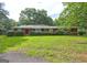Charming brick home with lush landscaping and mature trees on an expansive green lawn at 2742 Highway 20 W, Hampton, GA 30228