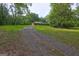 Brick home with a long gravel driveway and a large, wooded front yard at 2742 Highway 20 W, Hampton, GA 30228