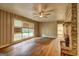 Unique living room featuring hardwood floors, stone fireplace, ceiling fan and large window at 2742 Highway 20 W, Hampton, GA 30228