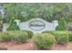 Community sign surrounded by mature trees, flowers, and landscaping at 70 N Strathmore Dr, Sharpsburg, GA 30277