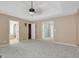 Spacious main bedroom featuring tray ceiling, fan, and multiple door entrances at 70 N Strathmore Dr, Sharpsburg, GA 30277