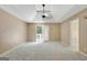 Spacious main bedroom featuring tray ceiling, fan, and private patio access at 70 N Strathmore Dr, Sharpsburg, GA 30277