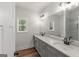 Bathroom with dual sinks, gray cabinets, granite counters, wood flooring and large vanity mirror at 4585 Parkwood Rd, Social Circle, GA 30025