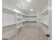 Spacious walk-in closet with custom shelves, hanging rods, and carpeted floor at 4585 Parkwood Rd, Social Circle, GA 30025