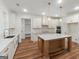Open kitchen with white cabinets, stainless steel appliances, and center island with marble countertop at 4585 Parkwood Rd, Social Circle, GA 30025