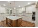 Bright, open kitchen with white cabinets, wood floors, and center island with marble countertop at 4585 Parkwood Rd, Social Circle, GA 30025