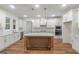 A bright, modern kitchen with white cabinetry, a center island, and stainless steel appliances at 4585 Parkwood Rd, Social Circle, GA 30025
