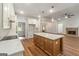 Open kitchen, center island with marble countertops and wood floors at 4585 Parkwood Rd, Social Circle, GA 30025