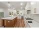 Modern kitchen with white cabinets, wood floors, and center island with marble countertops at 4585 Parkwood Rd, Social Circle, GA 30025