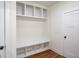 Well-organized mudroom featuring built-in bench with cubbies and coat hooks, and wood flooring at 4585 Parkwood Rd, Social Circle, GA 30025