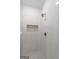 Tiled shower with rainfall shower head, soap niche, and mosaic tiled flooring at 4585 Parkwood Rd, Social Circle, GA 30025