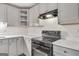 Well-lit kitchen features white cabinetry, quartz counters, and black appliances at 1834 Stroud Road, Mcdonough, GA 30252