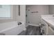 Bright bathroom with soaking tub, tiled shower, and gray wood-look tile flooring at 328 Brookstone Dr, Carrollton, GA 30116