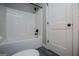 Bathroom featuring new, white shower/tub combo and gray wood-look flooring at 328 Brookstone Dr, Carrollton, GA 30116